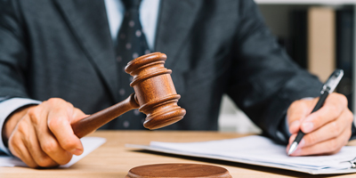 Judge writing with wooden gavel