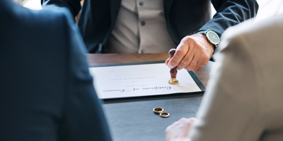 Solicitor stamping document with man and lady sat opposite